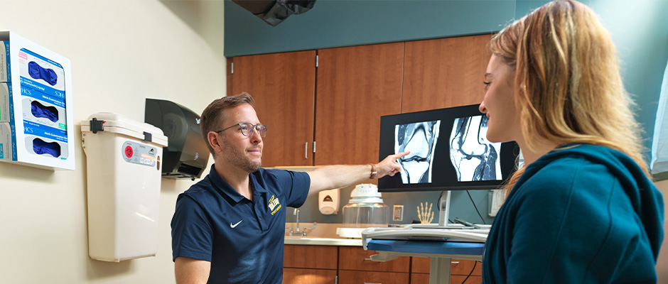 Dr. Miller with a patient and showing them x-rays of a knee