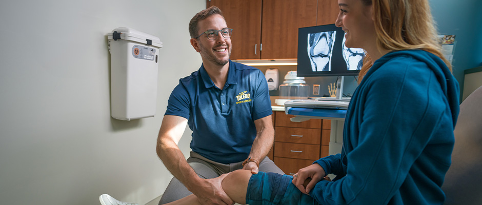 Dr. Miller with a patient and showing them x-rays of a knee