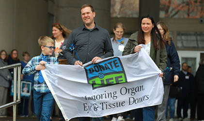 A family carring the donate life flag